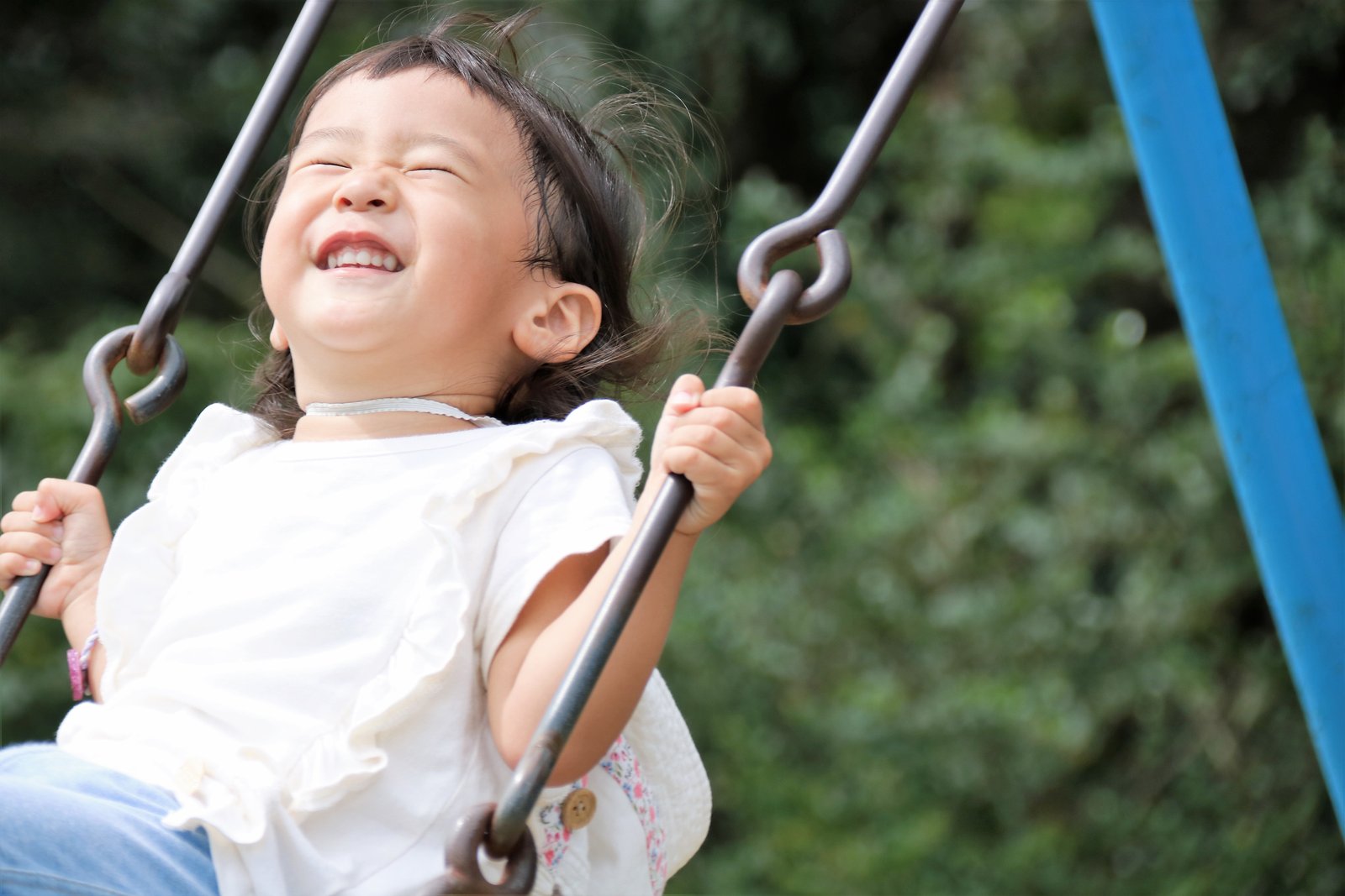 ブランコに乗って笑顔を見せる子ども